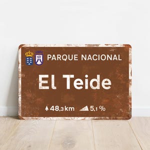 Può includere: Un cartello in stile vintage marrone e bianco con il testo "Parque Nacional El Teide" e la distanza e la pendenza fino al parco: 48,3 km e 5,1%.