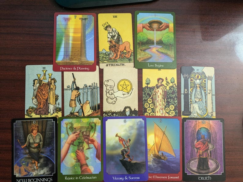 May include: A tarot card spread with ten cards, each featuring a different image and text. The cards are arranged in a row, with the first card on the left and the last card on the right. The cards are all in a similar style, with a colorful background and a central image. The text on the cards is in a black font and is easy to read. The cards are all in good condition and are ready to be used for a tarot reading.