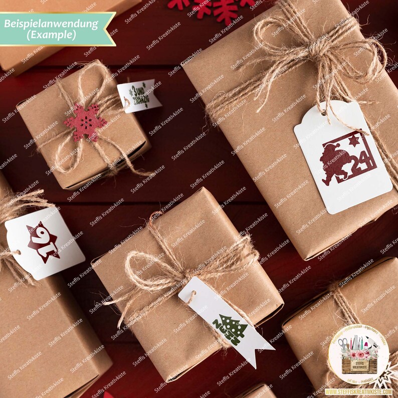 May include: A collection of small, brown gift boxes wrapped in twine and decorated with paper tags. The tags feature various Christmas-themed designs, including a snowflake, a Christmas tree, and a Santa Claus figure. The boxes are arranged on a wooden surface.