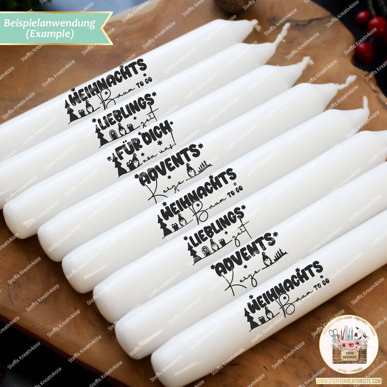 May include: White candles with black text that reads "Weihnacht's" and "Lieblings" with a Christmas tree design. The candles are arranged in a row on a wooden surface.