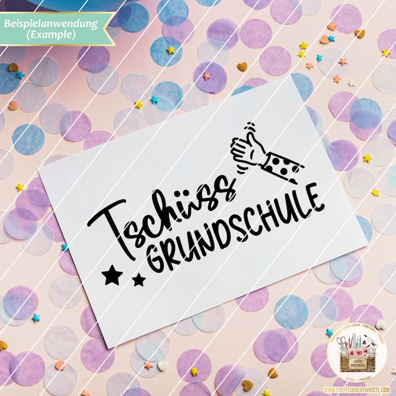 May include: A white card with black text that says "Tsch&uuml;ss Grundschule" with a black and white illustration of a hand giving a thumbs up. The card is on a pink background with confetti.