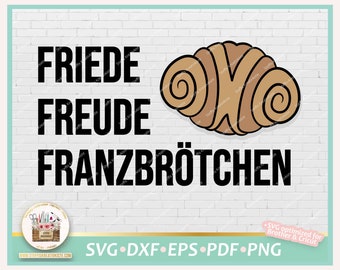 May include: A digital design featuring a cartoon illustration of a cinnamon roll with the text "FRIEDE FREUDE FRANZBRÖTCHEN" in black on a white brick background.