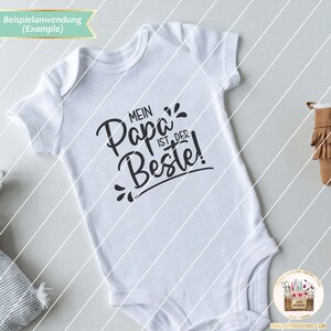 May include: White baby onesie with black text that reads "Mein Papa ist der Beste!" which translates to "My Dad is the Best!"