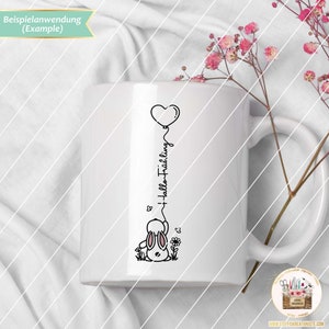 May include: White ceramic mug with a black and white illustration of a bunny holding a heart-shaped balloon. The text "Hallo Fr&uuml;hling" is written vertically on the balloon string.