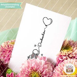 May include: A black and white line drawing of a bunny holding a heart-shaped balloon with the word "Dankesch&ouml;n" written on the string.
