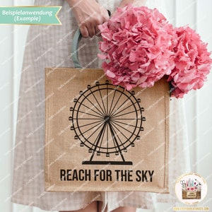 Pu&ograve; includere: Una borsa di tela di juta marrone con una silhouette nera di una ruota panoramica e il testo "REACH FOR THE SKY". La borsa &egrave; tenuta da una persona che indossa un vestito bianco e tiene un mazzo di ortensie rosa.