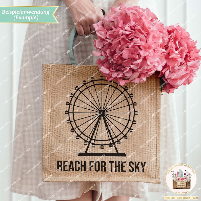 Pu&ograve; includere: Una borsa di tela di juta marrone con una silhouette nera di una ruota panoramica e il testo "REACH FOR THE SKY". La borsa &egrave; tenuta da una persona che indossa un vestito bianco e tiene un mazzo di ortensie rosa.