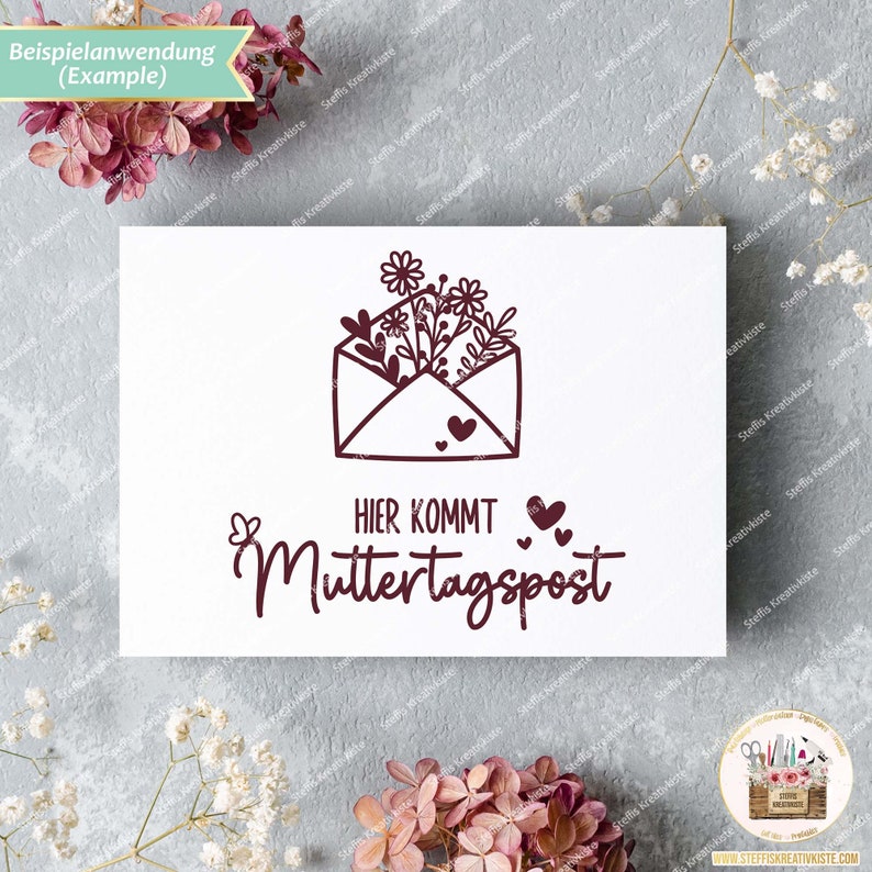 May include: A white card with a brown stamp featuring a floral design inside an envelope. The text "HIER KOMMT Muttertagspost" is below the stamp.