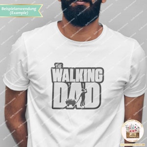 Op de afbeelding: Een wit T-shirt met een grijs grafisch ontwerp met de tekst "The Walking Dad" met een cartoonafbeelding van een persoon die een kruiwagen duwt.