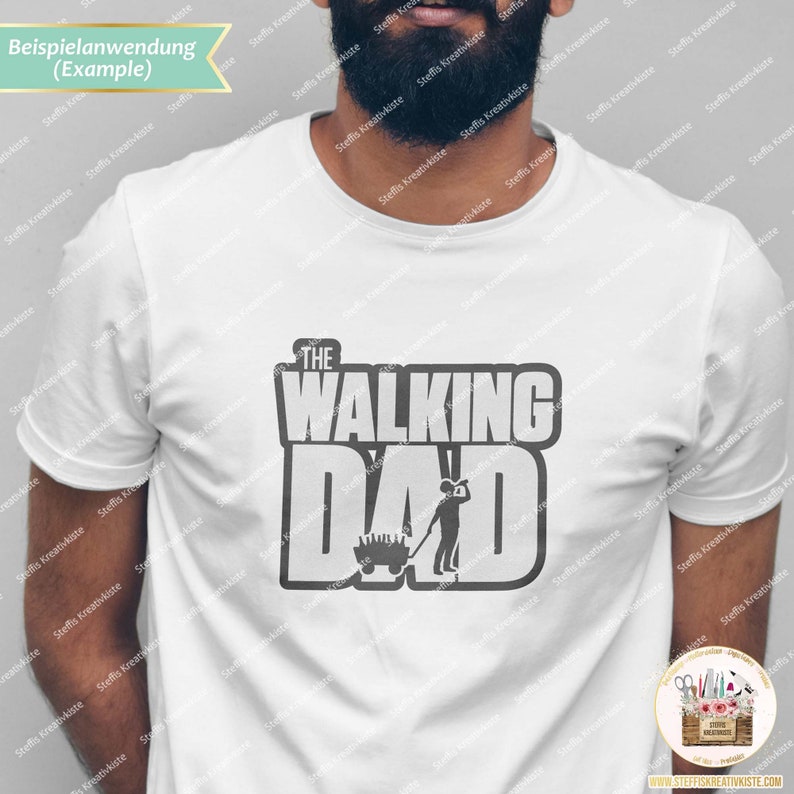 Op de afbeelding: Een wit T-shirt met een grijs grafisch ontwerp met de tekst "The Walking Dad" met een cartoonafbeelding van een persoon die een kruiwagen duwt.