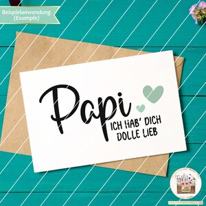 May include: A white card with black text that reads "Papi Ich hab' dich dolle lieb" with two green hearts.