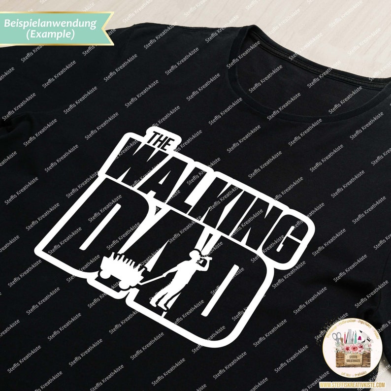 Op de afbeelding: Zwart T-shirt met een wit grafisch ontwerp met de tekst "The Walking Dad" met een cartoon afbeelding van een persoon die een kar duwt.