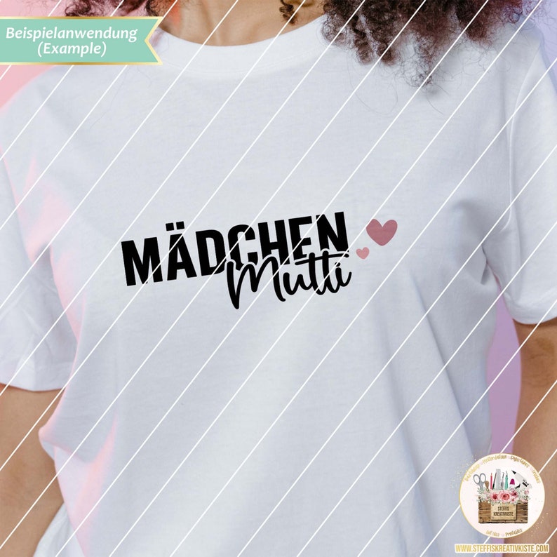 K&ouml;nnte beinhalten: Wei&szlig;es T-Shirt mit schwarzem Text "M&auml;dchen Mutti" und zwei rosa Herzen.