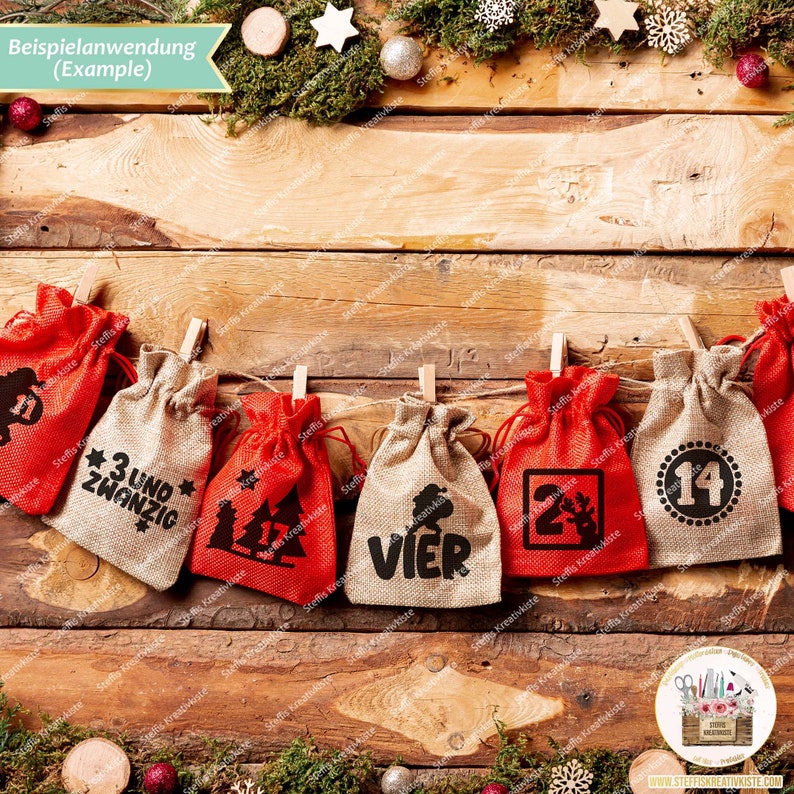 May include: A set of 7 red and beige burlap bags with numbers and German words printed on them. The bags are hung with clothespins on a wooden surface. The words on the bags are "11", "3 und zwanzig", "VIER", "24", and "14".