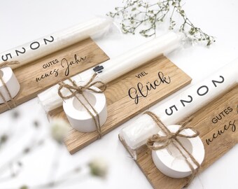 May include: Three wooden candle holders with white candles and twine. The holders have the text "Gutes neues Jahr", "Viel Glück", and "Gutes neues Jahr" written on them.