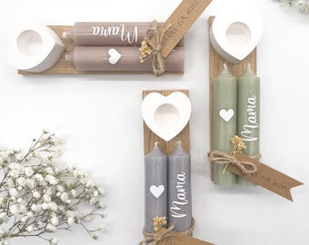 May include: Candle holders with heart-shaped accents and candles. The candles are in shades of gray and green, with the word "Mama" written on them. Each set includes a wooden base and a decorative tag.