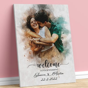 Pode incluir: Um sinal de boas-vindas de casamento em aquarela com uma foto de um casal se abra&ccedil;ando. O sinal diz "Bem-vindos ao nosso casamento Jessica & Austin 22-2-2022".