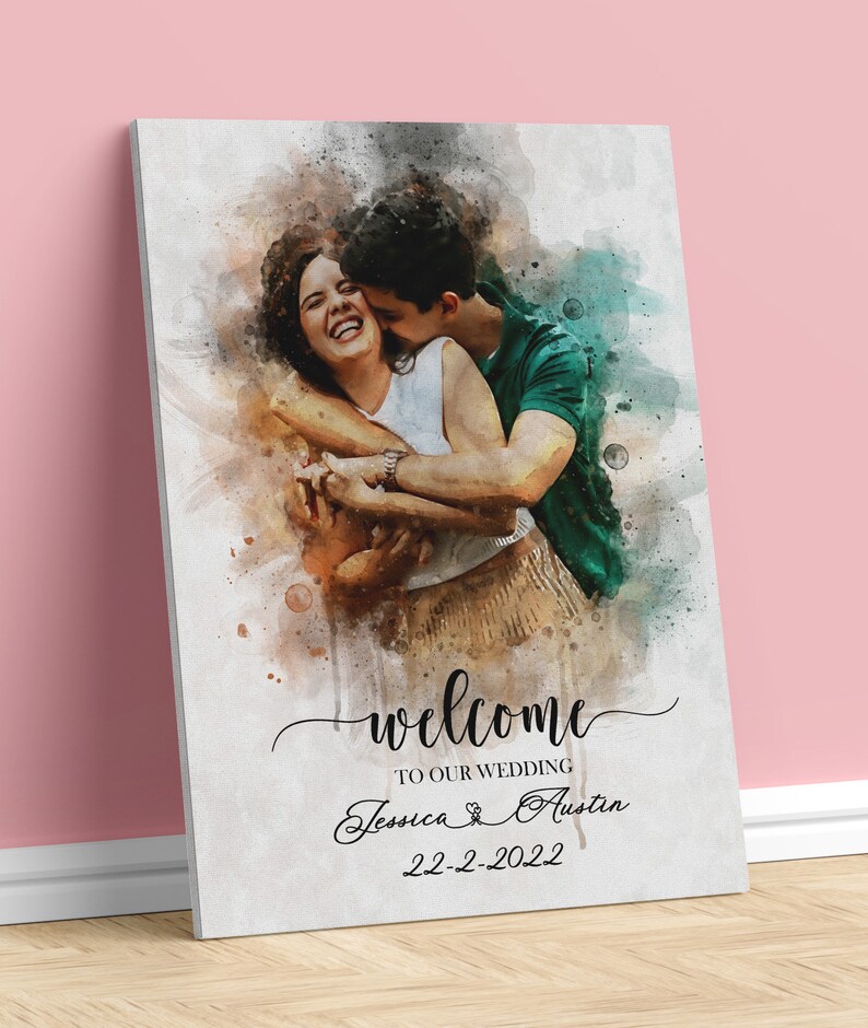 Pode incluir: Um sinal de boas-vindas de casamento em aquarela com uma foto de um casal se abra&ccedil;ando. O sinal diz "Bem-vindos ao nosso casamento Jessica & Austin 22-2-2022".