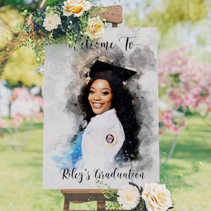 Pode incluir: Uma placa de boas-vindas em estilo aquarela para uma festa de formatura. A placa apresenta uma foto de um graduado usando um chap&eacute;u e uma beca, com o texto "Bem-vindo &agrave; formatura de Riley" na parte inferior.