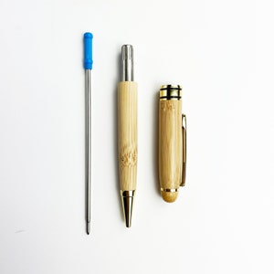 May include: Two bamboo pens with gold accents. One pen has a blue retractable tip and the other has a gold cap.