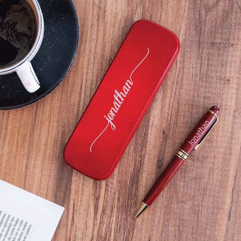 May include: A red pen and a red pen case with the name "Jonathan" engraved on it.