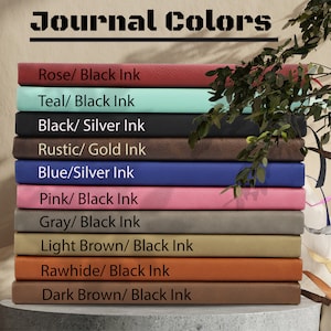 May include: A stack of ten leather-bound journals in various colors, including rose, teal, black, rustic, blue, pink, gray, light brown, rawhide, and dark brown. Each journal has a different color and is labeled with the color and ink color, such as "Rose/Black Ink" and "Teal/Black Ink".