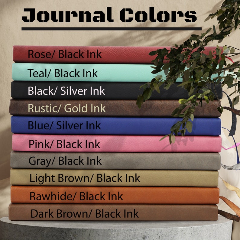 May include: A stack of ten leather-bound journals in various colours, including rose, teal, black, rustic, blue, pink, grey, light brown, rawhide, and dark brown. Each journal has a different colour and ink combination, as indicated by the text on the front of each journal.