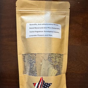 May include: A brown paper bag with a clear window, filled with dried herbs and leaves. The bag has a star-shaped design with red, white, and blue stripes. Text on the bag reads: "SpareMe, Anti-inflammatory Stress Relief Blend..." and lists ingredients.