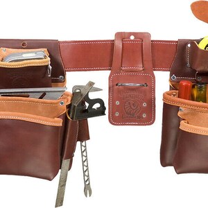 May include: A brown leather tool belt with multiple pockets and pouches. The belt has a hammer holder, a tape measure holder, and a variety of other pockets for tools. The belt is worn by a construction worker.
