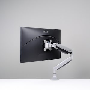 Może przedstawiać: Zestaw trzech ceramicznych kubków z nakrapianym, matowym wykończeniem. Kubki są w odcieniach kremu, jasnoszarym i ciemnoszarym. Każdy kubek ma prosty, minimalistyczny design i zaokrąglony uchwyt.