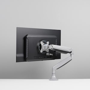 Op de afbeelding: Een zwarte computermonitor gemonteerd op een zilverkleurige verstelbare arm. De monitor is rechthoekig met een zwart frame. De arm heeft meerdere gewrichten voor flexibele positionering en is bevestigd aan een voet.