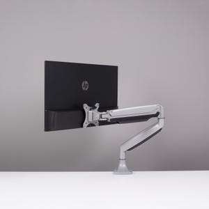 Op de afbeelding: Een zwarte HP computermonitor gemonteerd op een zilverkleurige verstelbare arm. De monitor heeft het HP-logo. De arm is bevestigd aan een basis, waardoor flexibele positionering mogelijk is.