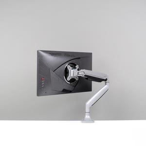 May include: A black computer monitor with the ASUS logo is mounted on a white and silver adjustable arm. The monitor is angled slightly, showcasing its back panel design. The arm is attached to a white base.