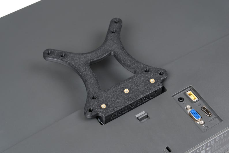 May include: A black, textured, 3D-printed bracket with brass-coloured screws, designed to mount on a grey surface. The bracket has a unique shape with multiple mounting holes and the text "CREATE3D" is visible.