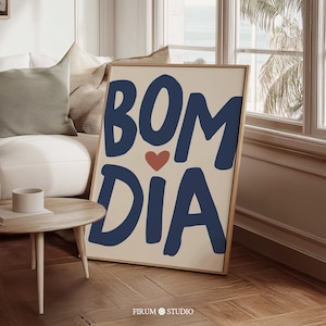 Peut inclure: Une affiche encadrée avec les mots "BOM DIA" en bleu marine, avec un petit cœur rouge. L'affiche a un fond beige et un cadre en bois. Le texte "FIRUM STUDIO" est en bas.