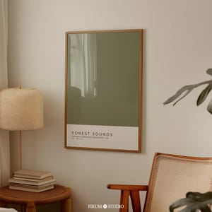 Op de afbeelding: Een ingelijste poster met een groene achtergrond en de tekst "FOREST SOUNDS" in wit. De poster hangt aan een witte muur.