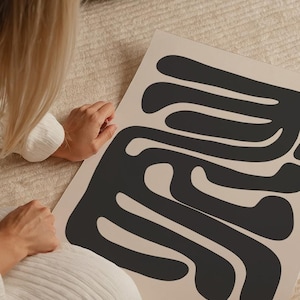 Beige and black abstract mid-century modern wall art featuring organic geometric shapes. This printable artwork blends minimalist aesthetics with neutral tones, perfect for contemporary living rooms, bedrooms, and offices. Available as a high-resolution digital download for instant printing