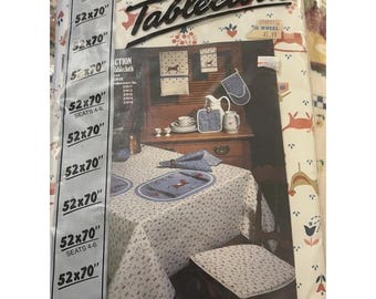 Vintage tafelkleed uit het midden van de 20e eeuw met folkloristische motieven, gemaakt van vinyl met een flanellen achterkant, met een huis, schommelpaard en bloemenprint.