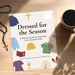 Puede incluir: Un libro titulado "Dressed for the Season" con ilustraciones de prendas de vestir. El subtítulo del libro dice "Una guía familiar para vestirse para el año litúrgico". Un rosario y una taza de café también son visibles en una superficie de madera.