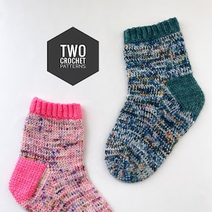 May include: Two crocheted socks, one pink with a fuchsia cuff and heel, the other blue with a teal cuff and heel. The socks have a speckled pattern. The image includes the text "TWO CROCHET PATTERNS" in a black hexagon.