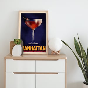 Pu&ograve; includere: Un poster in stile vintage con sfondo blu che presenta un bicchiere da cocktail pieno di una bevanda rossa e una ciliegia come guarnizione. Il testo "MANHATTAN" &egrave; in giallo con le parole "WHISKEY + VERMOUTH + BITTERS" in testo bianco pi&ugrave; piccolo sotto.