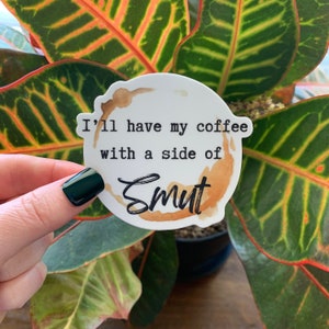 May include: White sticker with a brown coffee stain and the text "I'll have my coffee with a side of Smut".