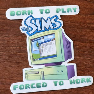 May include: A sticker featuring a retro computer with the words "The Sims" in a blue and white font. Above the computer is the text "BORN TO PLAY", and below it reads "FORCED TO WORK". The computer is green and purple.