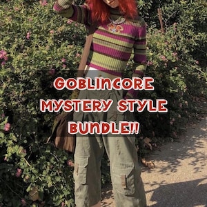 Op de afbeelding: Een persoon draagt een gestreept groen, paars en bruin shirt met lange mouwen en een olijfgroene cargobroek. De afbeelding bevat de tekst "GOBLINCORE MYSTERY STYLE BUNDLE!!"