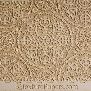 以下が含まれることがあります： 複雑な幾何学模様の白いエンボス加工が施されたベージュのテクスチャペーパー。パターンはペーパー全体に繰り返されています。ペーパーの下部に「TexturePapers.com」と「Design 100201」のテキストが印刷されています。