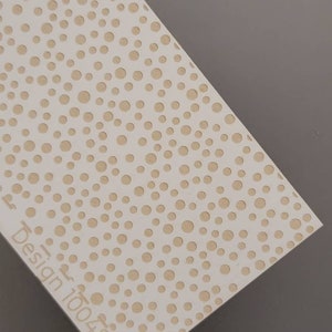 May include: White sheet of paper with a pattern of small, evenly spaced brown circles. The text "Design 100485" is printed in the lower left corner.