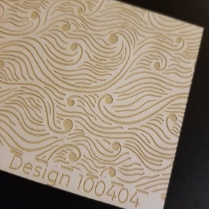 Op de afbeelding: Een wit oppervlak met een ontwerp van golvende lijnen en cirkels. De tekst "Design 100404" is afgedrukt in de rechterbenedenhoek.