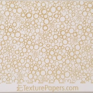 May include: A white background with a pattern of small, gold circles. The circles are of varying sizes and are arranged in a random pattern. The design is called "Design 100262" and is from TexturePapers.com.