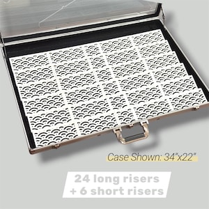 May include: A silver case containing white risers with a black wave pattern. The case is labeled "Case Shown: 86cm x 56cm" and the text "24 long risers + 6 short risers" is also visible.