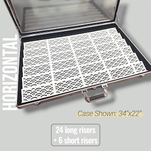 May include: An open silver case with a clear lid, filled with white risers featuring a black wave pattern. The case is labeled as 34" x 22" and includes 24 long and 6 short risers.